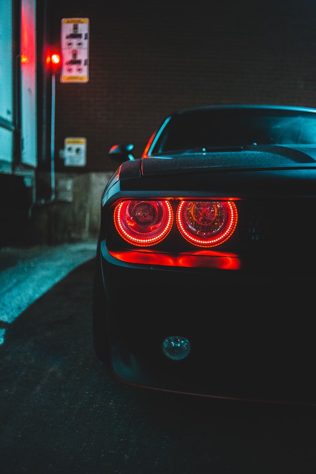 Custom Car Lighting - Picture of a black car at night with red head lights