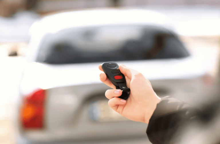 Upgraded car alarms - person holding key fob toward car