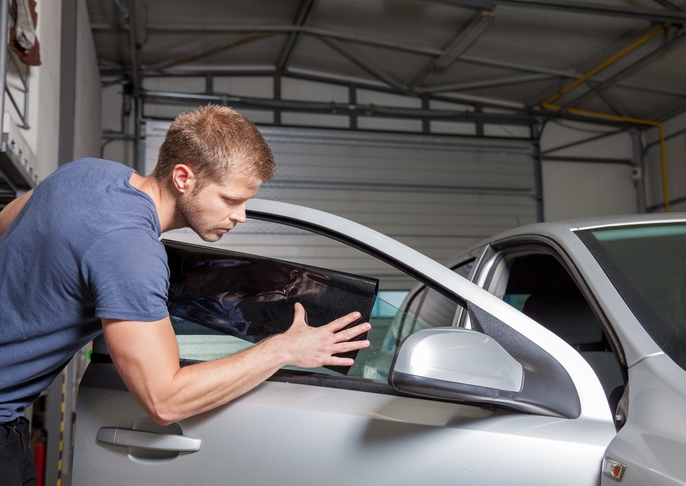 Man applying window tint to a vehicle