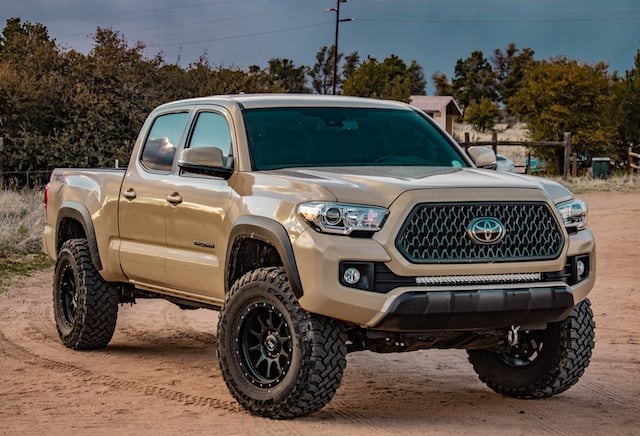 Truck Lift - Picture of a tan Toyota truck that has been lifted